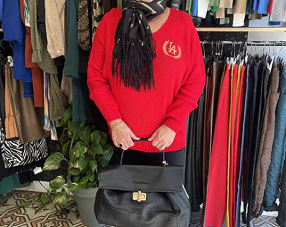 Mannequin posant avec un habit rouge et un sac à main noir élégant et en cuir